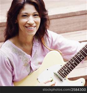 Portrait of a mature woman playing the guitar
