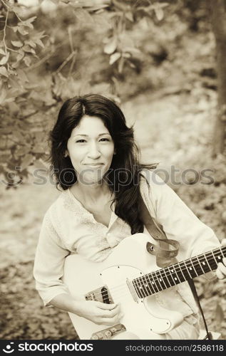 Portrait of a mature woman playing the guitar