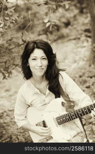 Portrait of a mature woman playing the guitar