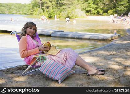 Portrait of a mature woman reclining on a deck chair and holding a pineapple