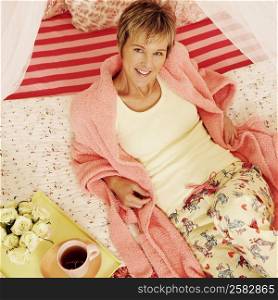Portrait of a mature woman reclining on the bed and smiling