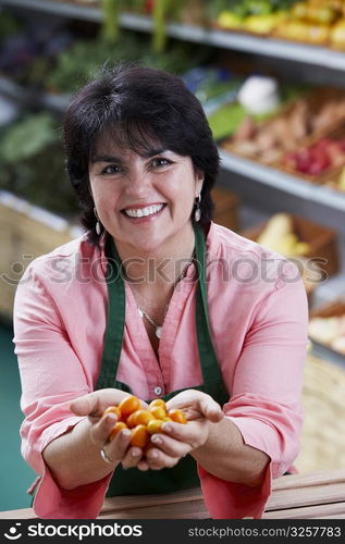 Portrait of a mature woman showing fruits and smiling