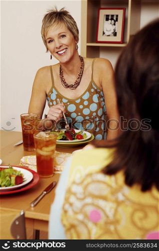 Portrait of a mature woman sitting at the dining table with her friend