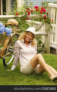 Portrait of a mature woman sitting beside a bicycle and smiling