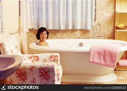 Portrait of a mature woman sitting in a bathtub and smiling