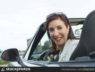 Portrait of a mature woman sitting in a car and smiling