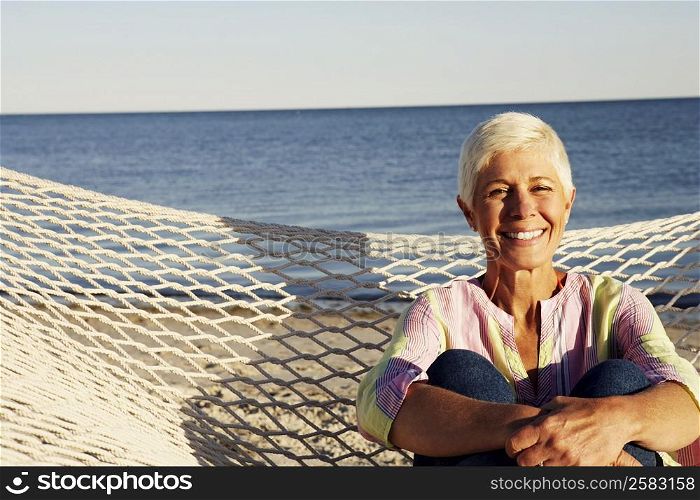 Portrait of a mature woman sitting in a hammock and smiling