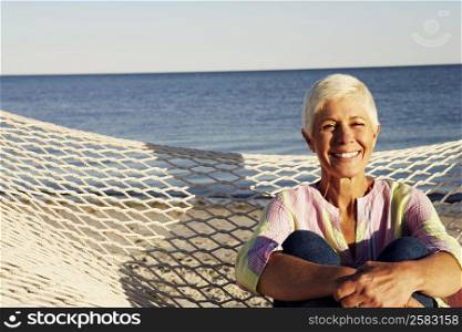 Portrait of a mature woman sitting in a hammock and smiling