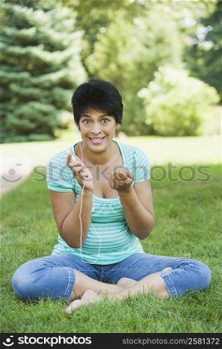 Portrait of a mature woman sitting in a park and listening to an MP3 player