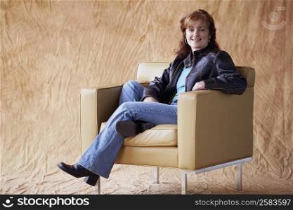 Portrait of a mature woman sitting in an armchair and smiling