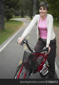 Portrait of a mature woman sitting on a bicycle and smiling