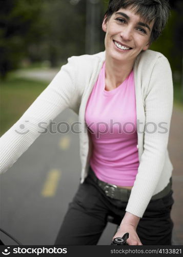 Portrait of a mature woman sitting on a bicycle and smiling