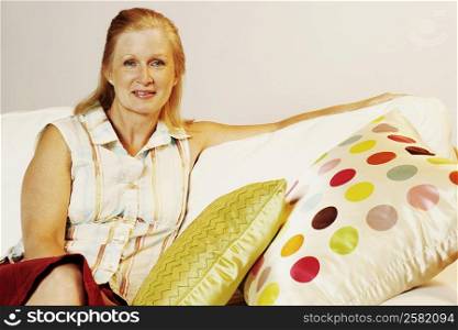 Portrait of a mature woman sitting on a couch and smiling