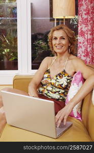 Portrait of a mature woman sitting on a couch with a laptop
