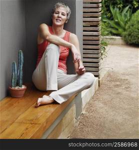 Portrait of a mature woman sitting on a ledge