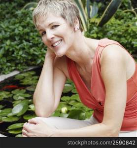 Portrait of a mature woman sitting on a ledge and smiling