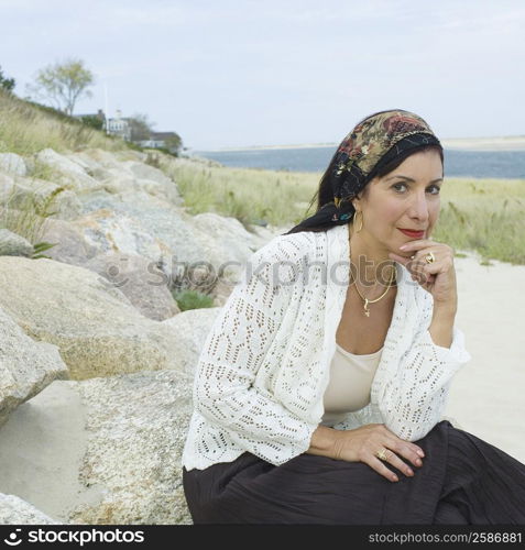 Portrait of a mature woman sitting on a rock and smiling
