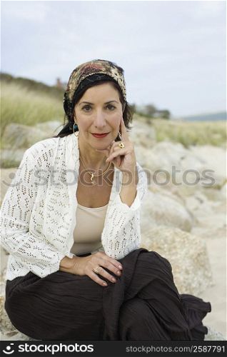 Portrait of a mature woman sitting on a rock and smiling