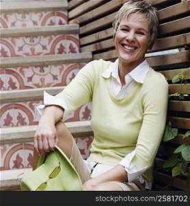 Portrait of a mature woman sitting on a staircase and smiling