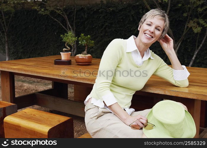 Portrait of a mature woman sitting on a stool and smiling