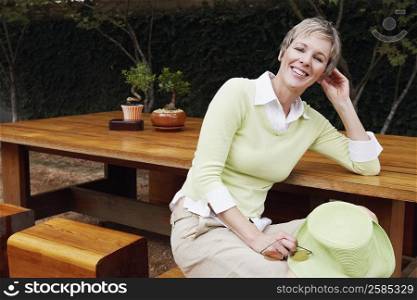 Portrait of a mature woman sitting on a stool and smiling