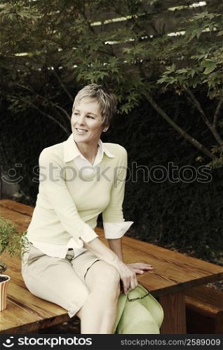 Portrait of a mature woman sitting on a table and smiling
