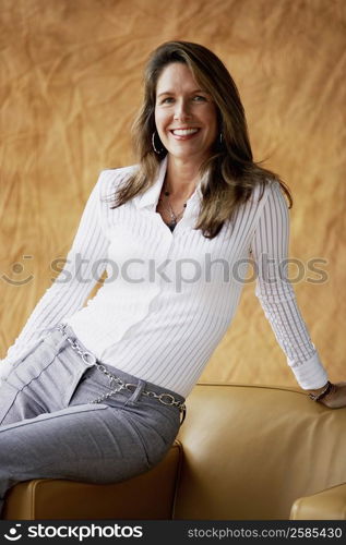 Portrait of a mature woman sitting on an armchair and smiling