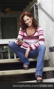 Portrait of a mature woman sitting on staircase and smiling