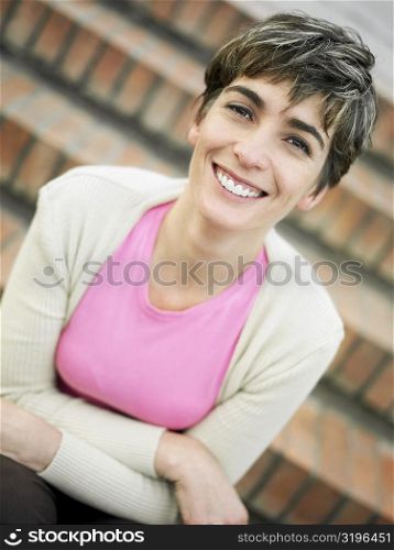 Portrait of a mature woman sitting on steps and smiling