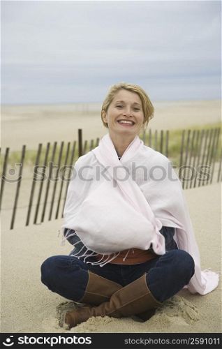 Portrait of a mature woman sitting on the beach and smiling