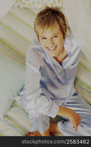 Portrait of a mature woman sitting on the bed and smiling