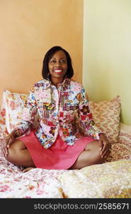 Portrait of a mature woman sitting on the bed and smiling