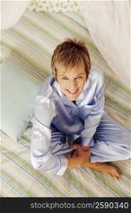 Portrait of a mature woman sitting on the bed and smiling