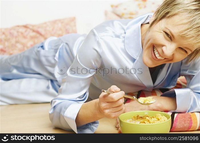 Portrait of a mature woman smiling and eating corn flakes