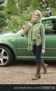 Portrait of a mature woman smiling in front of a car