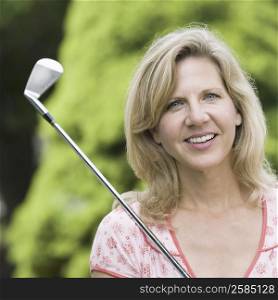 Portrait of a mature woman smiling with a golf club