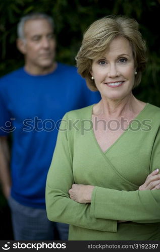 Portrait of a mature woman smiling with a senior man standing in the background
