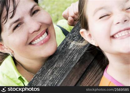 Portrait of a mature woman smiling with her daughter sitting on a bench