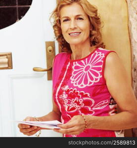 Portrait of a mature woman standing and holding papers