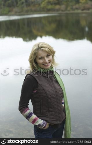 Portrait of a mature woman standing at the lakeside and smiling
