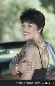 Portrait of a mature woman standing in front of a car and smiling