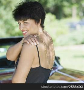 Portrait of a mature woman standing in front of a car and smiling