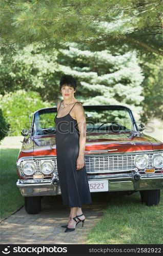 Portrait of a mature woman standing in front of a car in a lawn