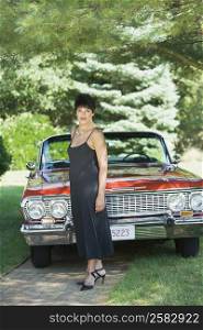 Portrait of a mature woman standing in front of a car in a lawn