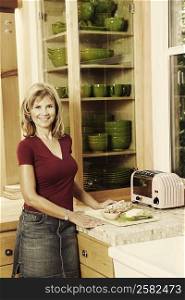 Portrait of a mature woman standing in the kitchen and smiling