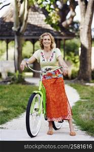 Portrait of a mature woman standing with a bicycle
