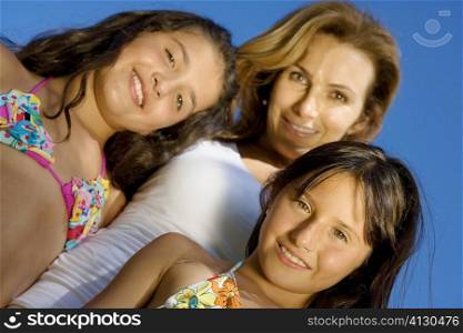 Portrait of a mature woman standing with her two daughters and smiling