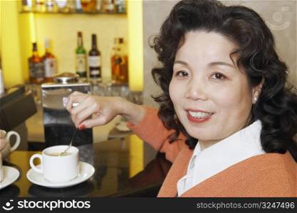 Portrait of a mature woman stirring a cup of coffee
