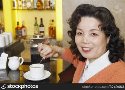 Portrait of a mature woman stirring a cup of coffee