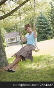 Portrait of a mature woman swinging on a rope swing